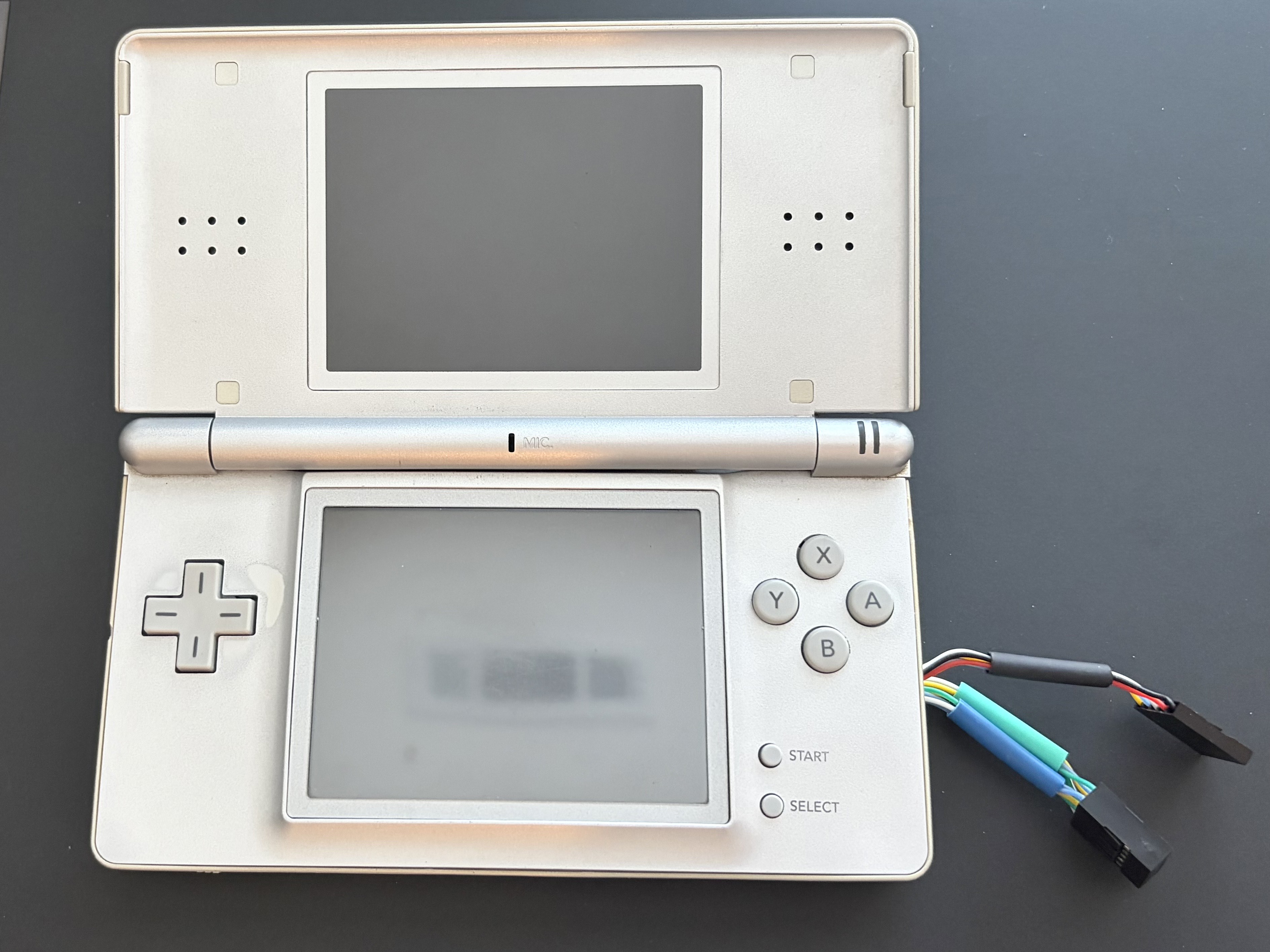 Reassembled Nintendo DS Lite with button connectors exposed at the side